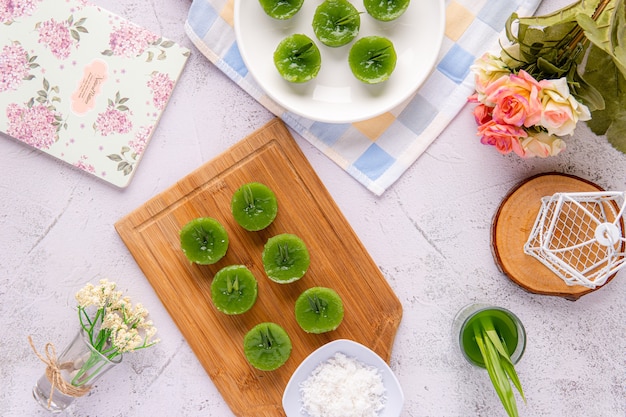 Kue Lumpang Pandan Lub Kue Ijo Kue Ijo To Tradycyjne Zielone Ciasto O Niewielkich Rozmiarach Gotowane Na Parze O Gumowatej Konsystencji Podawane Z Tartym Kokosem. Popularna Przekąska Z Indonezji