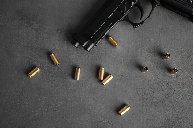 Zdjęcie kule i pistolet na szarym stole