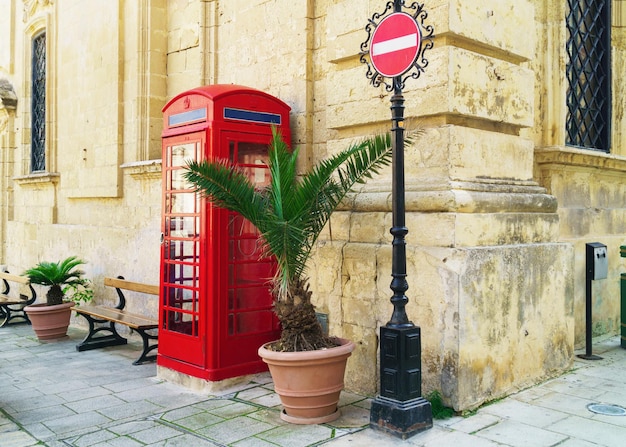 Kultowa czerwona budka telefoniczna w maltańskim mieście Mdina. Koncepcja edukacji szkoły języka angielskiego Malta. Skopiuj tapetę miejsca lub kartę podarunkową.