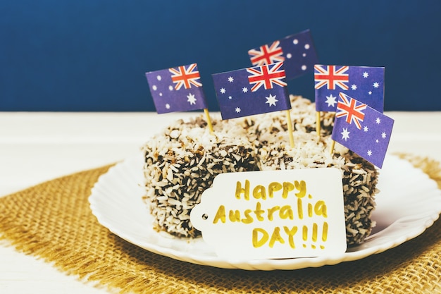 Kultowe tradycyjne australijskie przyjęcie, ciasta Lamington na czerwonym, białym i niebieskim tle. Flaga Australii.