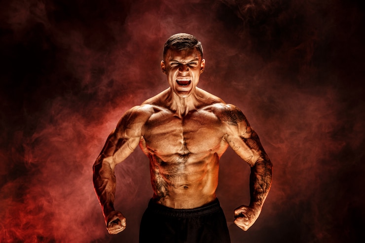 Zdjęcie kulturysta pozowanie fitness wytatuowany umięśniony mężczyzna na scenie czerwony dym