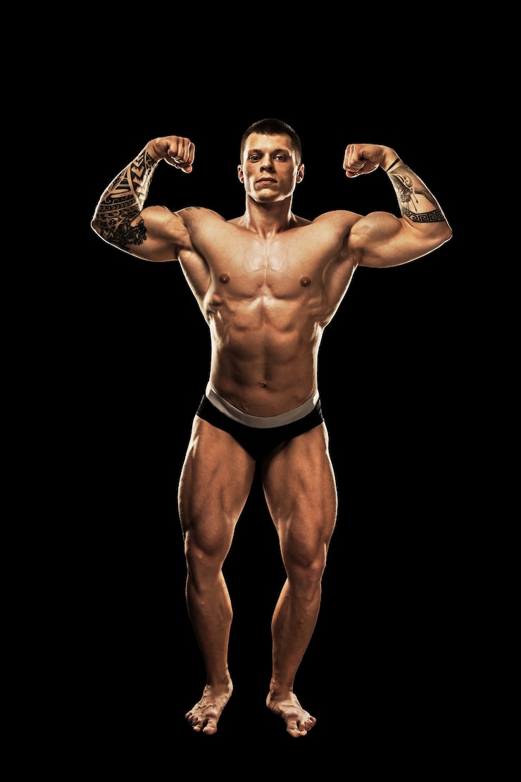 Zdjęcie kulturysta pozowanie. piękny sportowy facet męskiej mocy. fitness mięśni ciała. na białym tle na czarnym tle