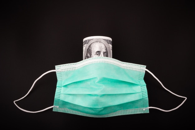 Zdjęcie kupie sto dolarów chronione maską medyczną