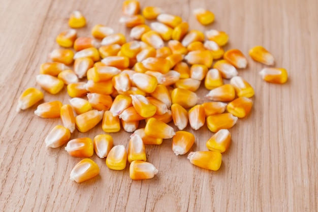 Kupie surowych kukurydzy nasiona kukurydzy lub ziaren kukurydzy na drewnianym tle selektywne focus