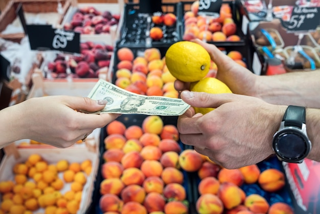 Kupujący Daje Pieniądze Sprzedawczyni Za Owoce W Supermarkecie. Zdrowy Tryb życia