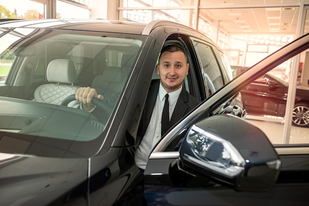 Kupujący klient wewnątrz nowoczesnego samochodu w salonie pokazowym koncepcja sprzedaży lub wynajmu pojazdów transportowych