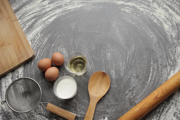 Kurczak jajko mąka oliwa z oliwek mleko kuchenne narzędzie na szarym tle stołu