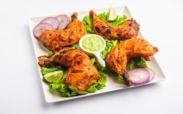 Kurczak Tandoori to danie z kurczaka przygotowane przez pieczenie kurczaka marynowanego w jogurcie i przyprawach w piecu tandoor lub glinianym, podawane z cebulą i zielonym chutney