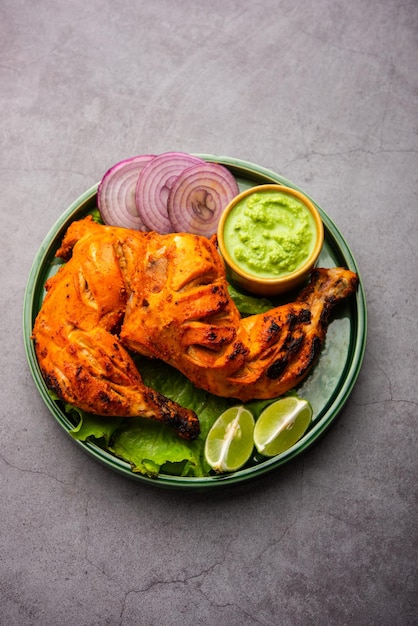Kurczak Tandoori to danie z kurczaka przygotowane przez pieczenie kurczaka marynowanego w jogurcie i przyprawach w piecu tandoor lub glinianym, podawane z cebulą i zielonym chutney