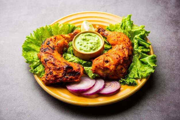 Kurczak Tandoori to danie z kurczaka przygotowane przez pieczenie kurczaka marynowanego w jogurcie i przyprawach w piecu tandoor lub glinianym, podawane z cebulą i zielonym chutney