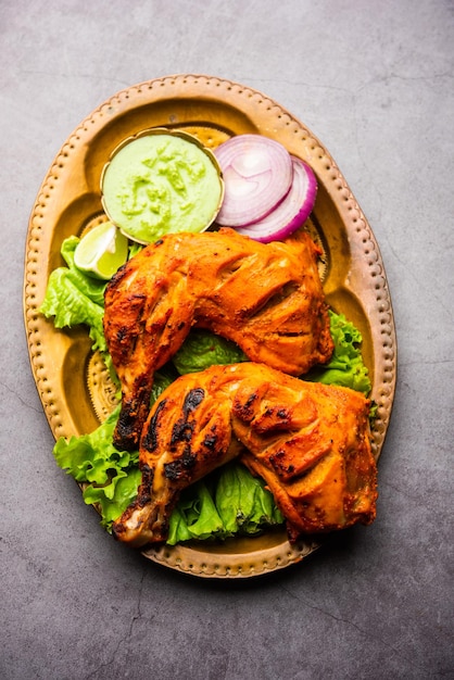 Kurczak Tandoori to danie z kurczaka przygotowane przez pieczenie kurczaka marynowanego w jogurcie i przyprawach w piecu tandoor lub glinianym, podawane z cebulą i zielonym chutney