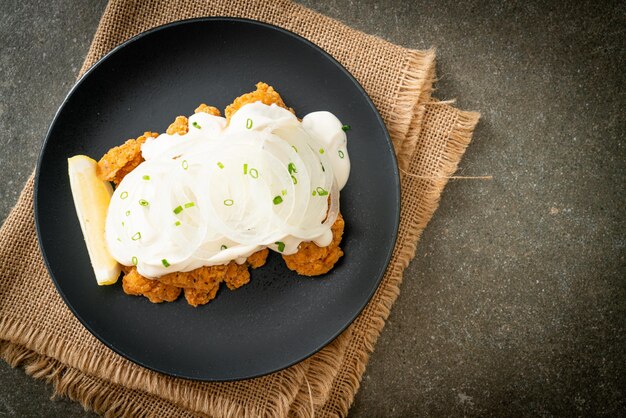 Zdjęcie kurczak ze śnieżną cebulą lub kurczak smażony z kremowym sosem cebulkowym z cytryną po koreańsku - po koreańsku