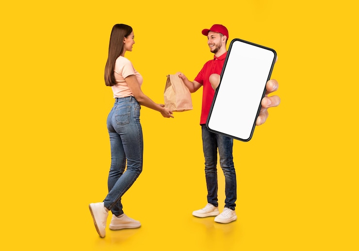 Zdjęcie kurier męski aplikacji dostawy trzymający pusty smartfon i dający pakiet klientowi