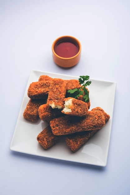 Kurkuri paneer finger lub pakora, przekąski pakoda znane również jako Crispy Cottage Cheese Bars, podawane z keczupem jako przystawką. selektywne skupienie