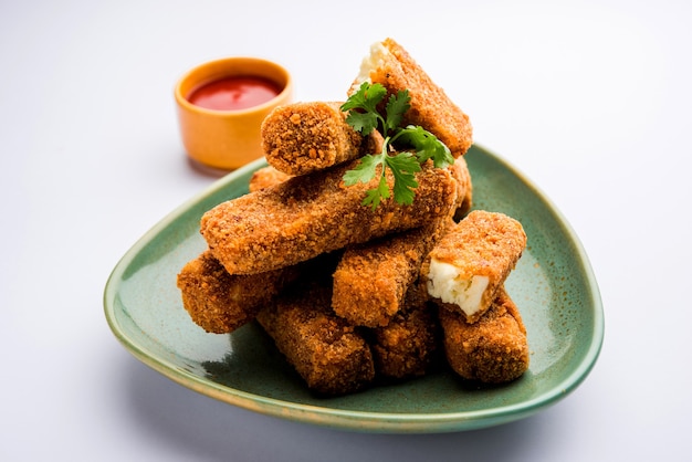 Kurkuri paneer finger lub pakora, przekąski pakoda znane również jako Crispy Cottage Cheese Bars, podawane z keczupem jako przystawką. selektywne skupienie