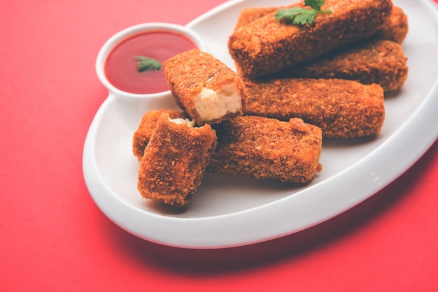 Kurkuri paneer finger lub pakora, przekąski pakoda znane również jako Crispy Cottage Cheese Bars, podawane z keczupem jako przystawką. selektywne skupienie