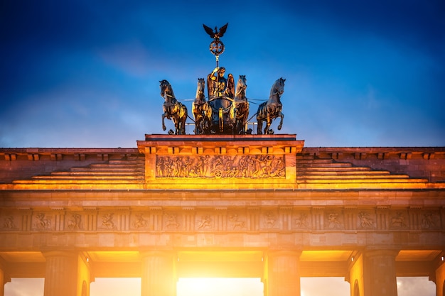 Zdjęcie kwadryga na szczycie bramy brandenburskiej w wieczornym oświetleniu berlin