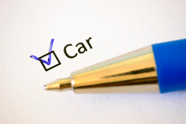Kwestionariusz Niebieski długopis i napis CAR ze znacznikiem wyboru na białym papierze