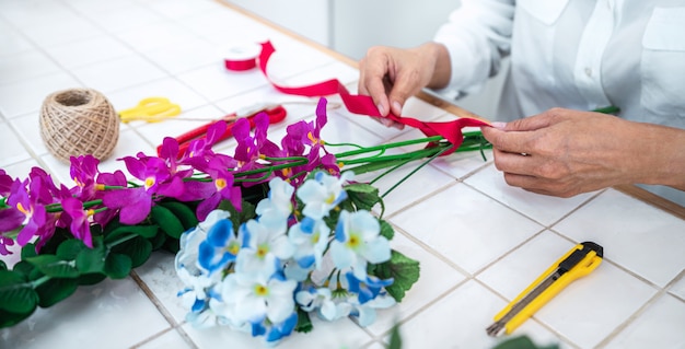 Zdjęcie kwiaciarnia młoda kobieta robi diy sztuczne kwiaty