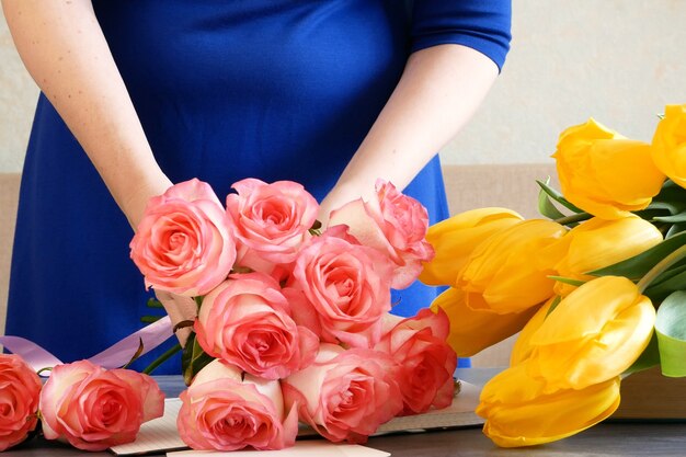 Zdjęcie kwiaciarnia w miejscu pracy, kwiaciarnia robi bukiet z róż