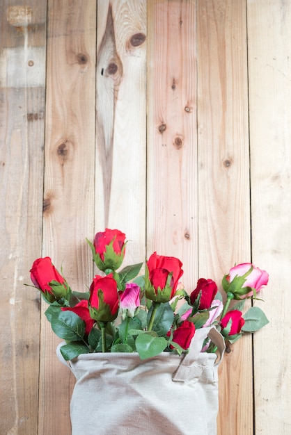 kwiat róży w doniczce wazon, w kawiarni stół z drewnianym tle