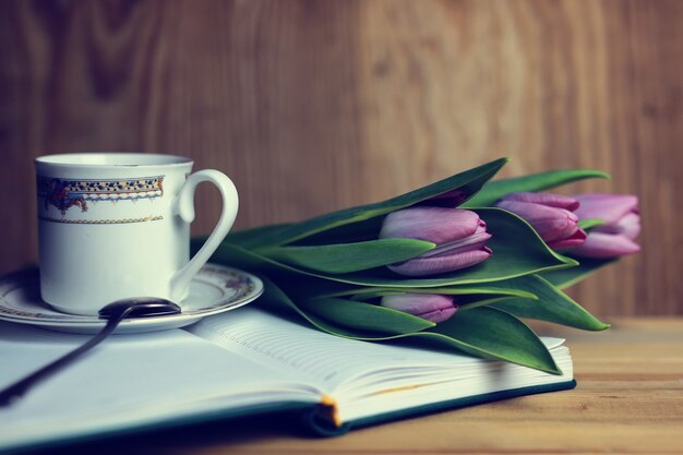 Zdjęcie kwiatek na księdze i herbata