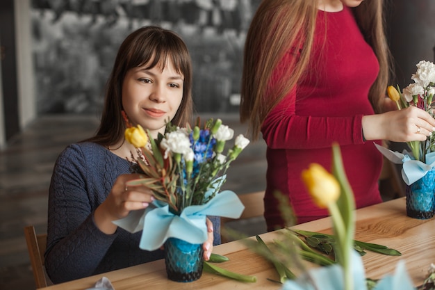 Kwiatowa klasa maser. Kobiety tworzące kompozycję kwiatową ze świeżych kwiatów.