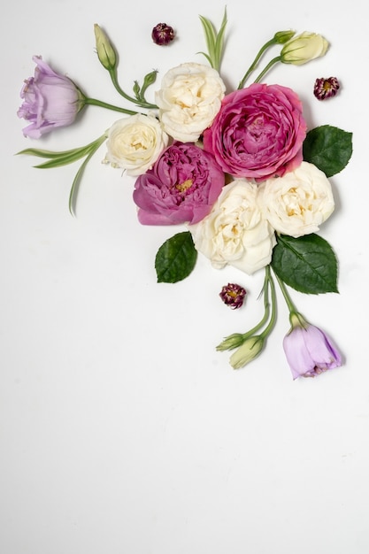 Zdjęcie kwiatowa ramka na szarej powierzchni. widok z góry i miejsce na kopię. delikatne liliowe róże i eustoma. kompozycja narożna. wysokiej jakości zdjęcie