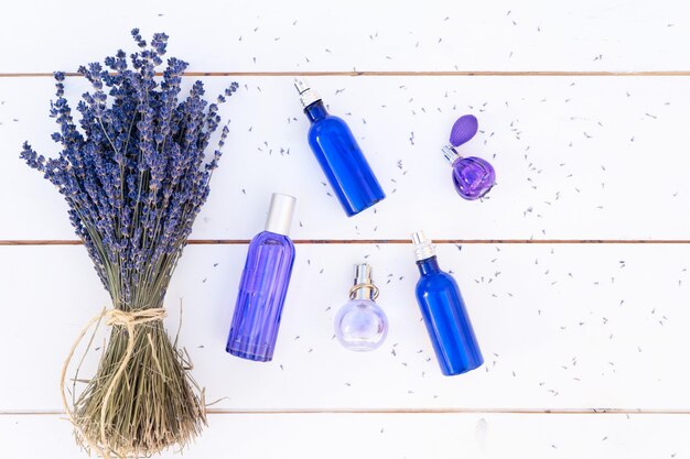 Kwiaty lawendy i olejek lawendowy oraz produkty w niebieskich butelkach