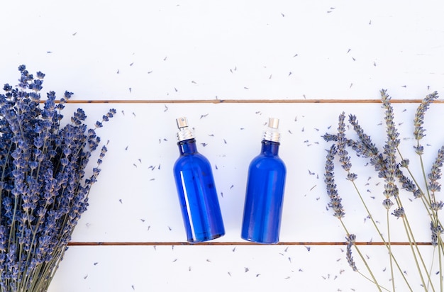 Kwiaty lawendy i olejek lawendowy w niebieskich butelkach, widok z góry