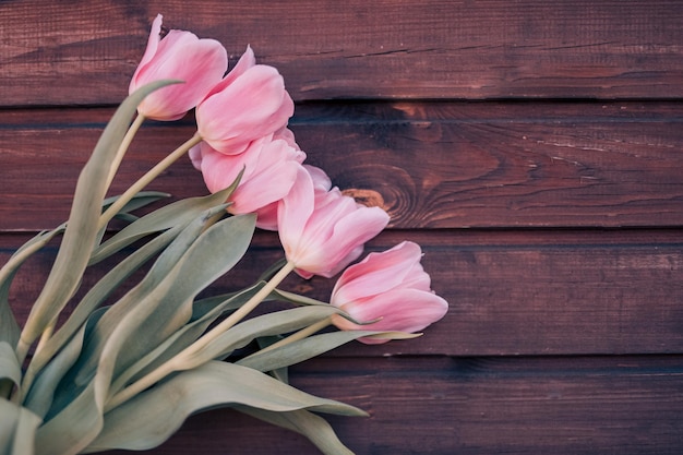 Kwiaty. Różowe tulipany na drewnianym tle z miejscem na tekst, styl vintage kolorów