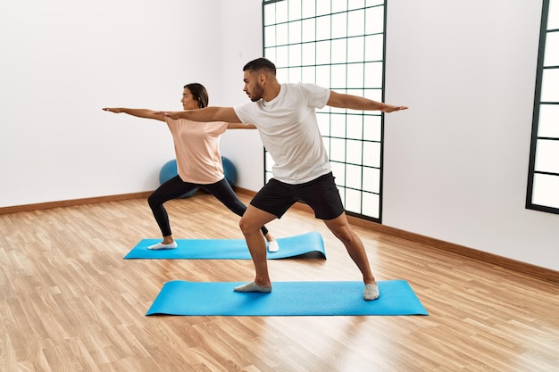 Łacińska para mężczyzna i kobieta trenuje jogę w centrum sportowym