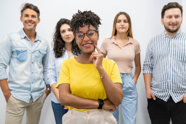 Ładna afro kobieta w coworkingu z kolegami z tyłu, szefie