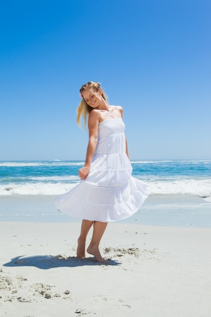 Ładna beztroska blondynki pozycja na plaży