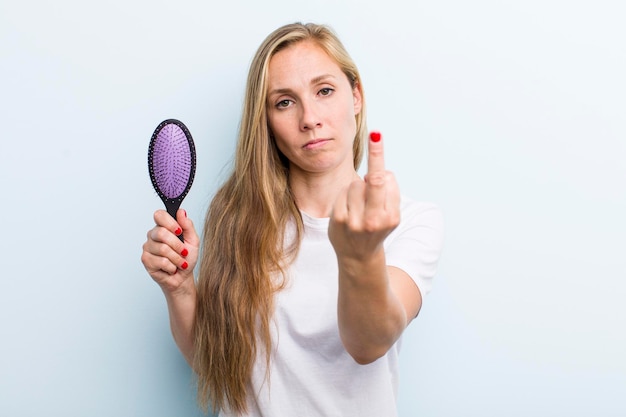 Ładna blond młoda dorosła kobieta z grzebieniem do włosów