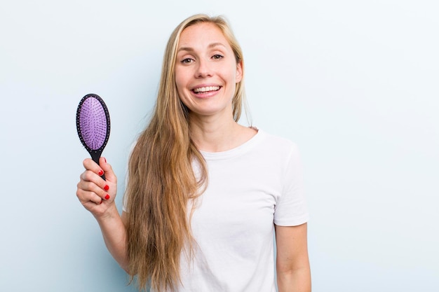 Ładna blond młoda dorosła kobieta z grzebieniem do włosów