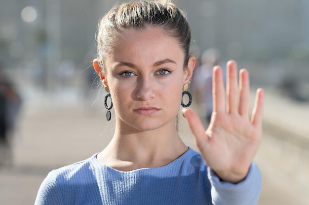 Ładna blondynka robi gest stop ręką