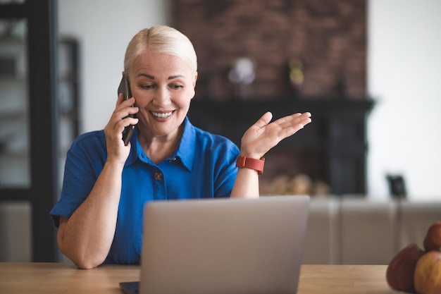 Zdjęcie Ładna blondynka rozmawia przez telefon i wygląda na zadowoloną