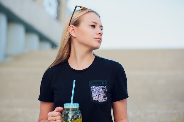 Zdjęcie Ładna blondynki dziewczyna z szklaną odświeżającą lemoniadą