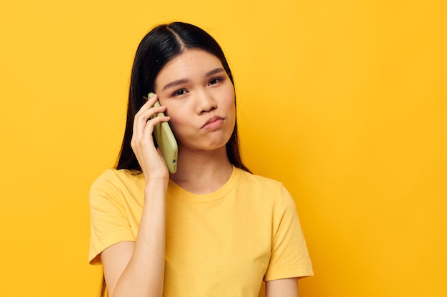 Ładna brunetka komunikacja telefoniczna zabawa używa izolowanego tła bez zmian