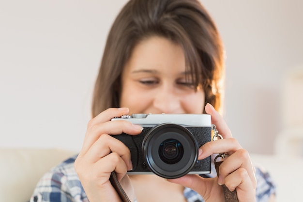 Ładna brunetka patrzeje retro kamerę na leżance