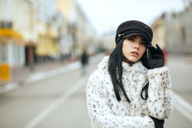 ładna brunetka ubrana w stylową czapkę i ciepły płaszcz