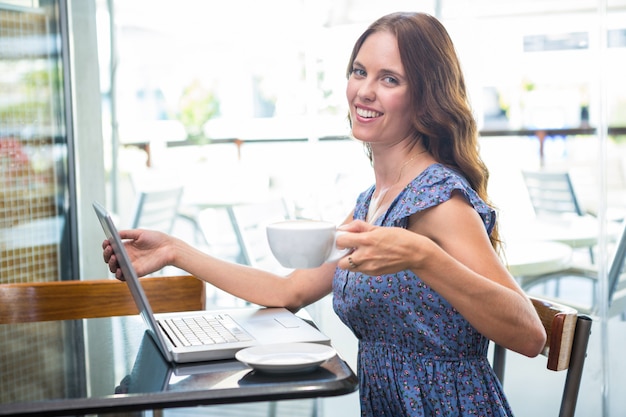 Ładna brunetka używa jej laptop