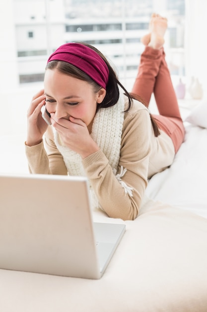 Zdjęcie Ładna brunetka używa laptop na łóżku