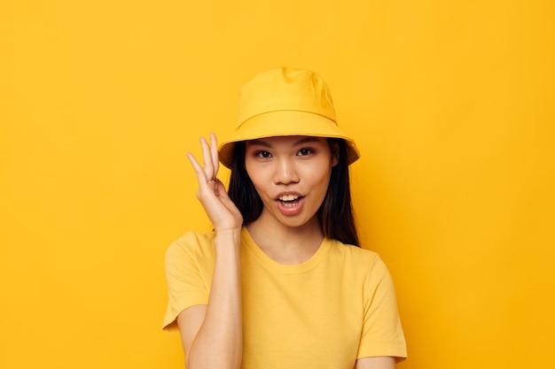 Ładna brunetka w żółtym kapeluszu pozuje niezmienione emocje modelka studyjna