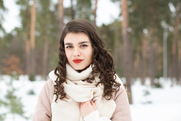 Ładna brunetka z długimi włosami nosi płaszcz w zimie