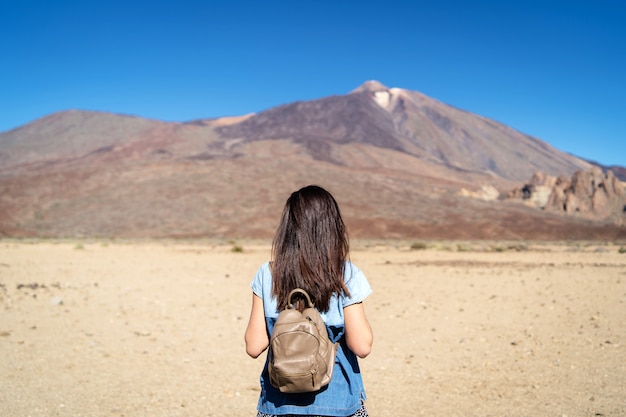 Ładna brunetki dziewczyna chodzi plenerowego pobliskiego teide wulkan na Tenerife wyspie.
