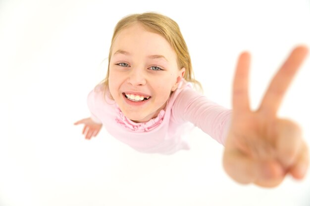 Ładna dziewczyna pokazuje dwa palce do kamery. Widok z góry
