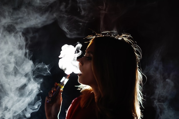 Ładna dziewczyna viper dym e-papierosa w nocnym klubie