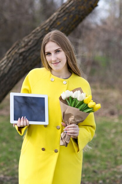 Ładna dziewczyna w żakiecie z pastylką i kwiatami